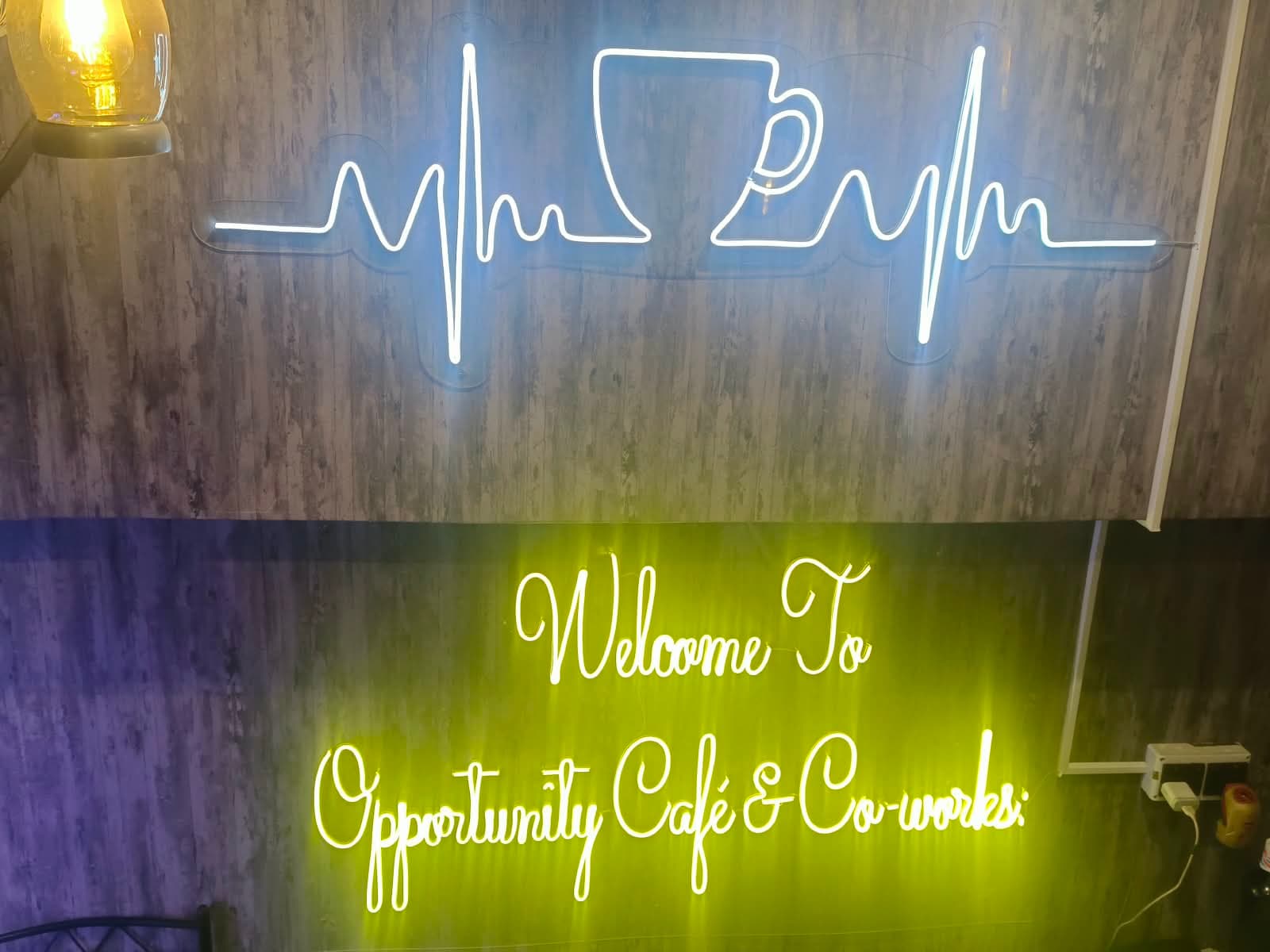 LED neon coffee-cup heartbeat sign and a Welcome to Opportunity Cafe neon script